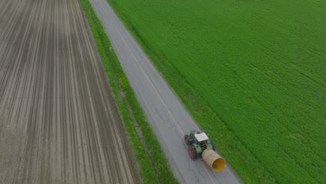 Harvester-Farm-Tractor-Is-Driving-Across-The-Road-Through-The-Fields