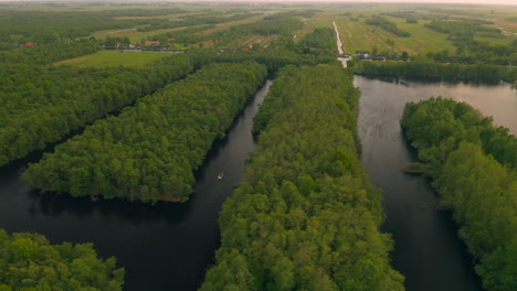 Langboot-Segelt-Im-Polder-Mit-üppigen-Grünen-Bäumen,-Die-An-Jedem-Ufer-In-Den-Niederlanden-Wachsen