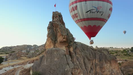 Hot-air-balloons-carrying-tourists-glide-over-Cappadocia-during-sunrise-in-Nevsehir,-Turkey-on-october-12