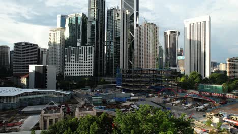 Luftdrohne-Mit-Blick-Auf-Ein-Industriebaugebiet-In-Der-Innenstadt-Von-Kuala-Lumpur,-Malaysia-An-Einem-Sonnigen-Tag,-Während-Die-Sonne-Untergeht-Und-Die-Großartige-Skyline-Und-Viele-Wolkenkratzer-überblickt