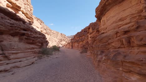 Blick-Auf-Die-Schattige,-Von-Sandsteinmauern-Umgebene-Schlucht-In-Ägypten-Mit-Touristen-Im-Hintergrund