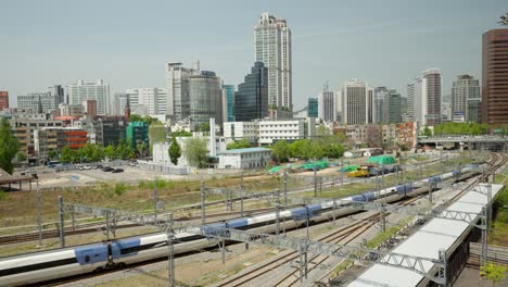 KTX-train-traveling-to-Seoul-Station-with-Panorama-of-Downtown-CIty---elevated-view