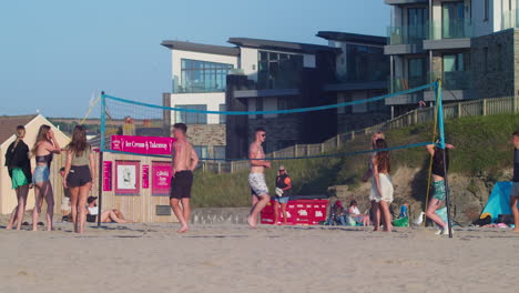 Gruppe-Junger-Leute,-Die-Volleyball-Am-Perranporth-Beach-In-Cornwall,-England,-Großbritannien-Spielen