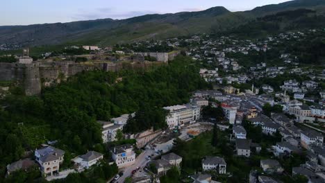 Aerial-view-of-old-city-center-of-ancient-forts,-castles,-houses-and-mountains-in-Gjirokaster,-Albania