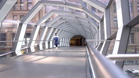 Ein-Einsamer-Mann-Schlendert-über-Die-Verdrehte-Geometrische-Glasbrücke-Im-CF-Toronto-Eaton-Centre,-Mit-Blick-Auf-Die-Straße-Unten-–-Einkaufszentrum-Ontario,-Kanada,-Mit-Einer-Person,-Die-Es-überquert