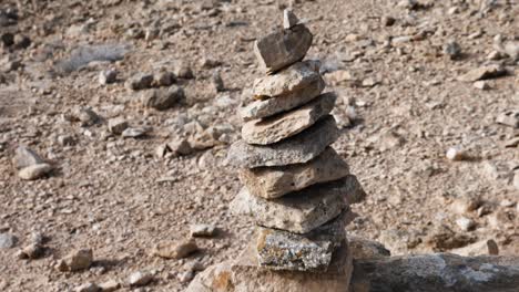 closeup-of-conical-stone-cairn-to-a-reveal-of-the-barren-landscape-behind