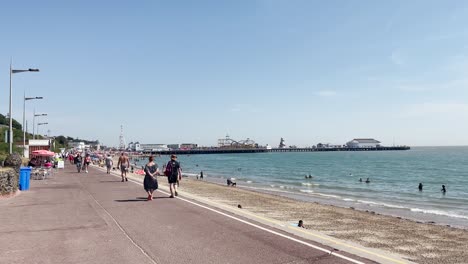 Gente-Disfrutando-Del-Clima-Soleado-En-El-Paseo-Marítimo-De-Clacton-On-Sea,-Essex,-Reino-Unido