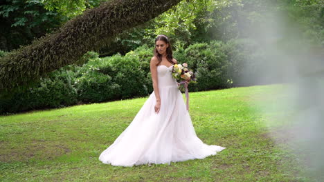Beautiful-young-bride-posing-in-a-garden-with-a-huge-bouquet-before-a-luxury-wedding