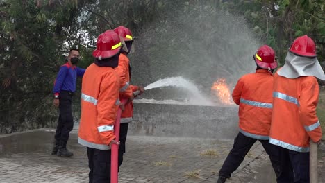 Feuerwehrmann-Zieht-Einen-Orangefarbenen-Anzug-An,-Löscht-Ölbeckenbrand,-Ölaustritt-Nach-Unfall