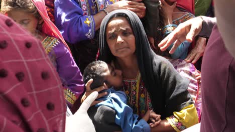 Madre-Sosteniendo-A-Un-Niño-Discapacitado-En-Un-Campamento-De-Socorro-Por-Inundaciones-En-Sindh,-Pakistán