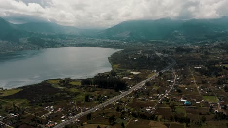 Comunidad-Próspera-Frente-A-La-Orilla-Del-Lago-De-La-Laguna-De-San-Pablo-En-Otavalo,-Ecuador-Junto-Al-Volcán-Imbabura