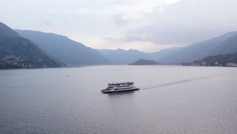 Passenger-Ferry-Boat-on-Picturesque-Lake-Como,-with-Italy-Alps-Mountains-in-Background,-Aerial-with-Copy-Space