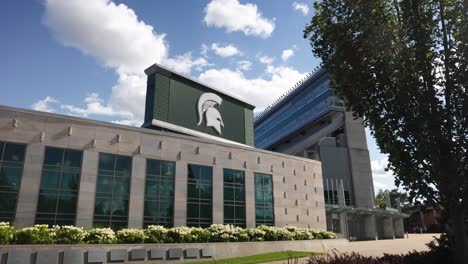 Außenansicht-Des-Spartan-Stadions-Auf-Dem-Campus-Der-Michigan-State-University-In-East-Lansing,-Michigan-Mit-Zeitlupenschwenk-Von-Links-Nach-Rechts-Und-Im-Wind-Wehenden-Bäumen