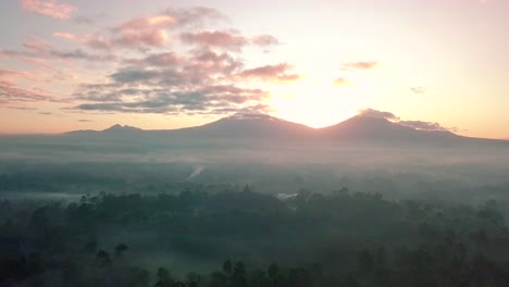 Toma-Cinematográfica-Del-Famoso-Templo-De-Borobudur-Con-Amanecer-Y-Montañas-En-El-Fondo-Y-Cielo-Nublado---Magelang,-Indonesia