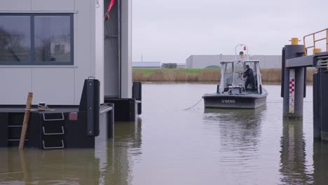 Man-working-on-a-boat-in-the-harbor-in-industrial-transport-area