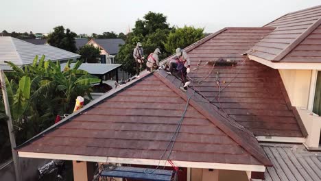 Asian-Technician-Work-on-Roof-Installation,-Aerial-Shot