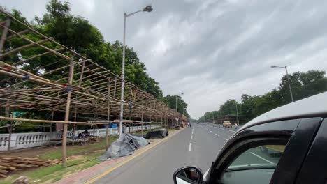 POV-of-a-driver-driving-a-car-while-passing-numerous-runners-and-joggers,-as-well-as-a-cab-travelling-beside-the-vehicle-and-several-other-vehicles-in-the-other-lane