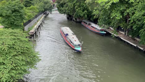 Boat-travel-at-Bangkok-Yai-Canal-on-a-sunny-day,-Phasi-Charoen,-Thailand