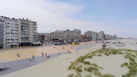 People-walk-and-enjoy-in-summertime-in-scenery-town-near-the-Belgian-beach,-Nieuwpoort,-Belgium