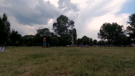 two-people-playing-badminton-in-park,-still-low-angle-time-lapse-shot