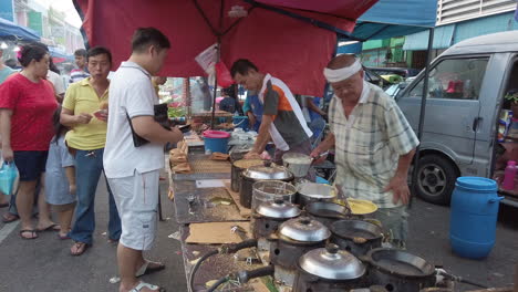 Un-Hombre-Haciendo-Panqueques-Justo-En-Frente-De-Otro-Hombre-Con-Una-Campana-De-Cocina-Hecha-A-Sí-Mismo-En-Primer-Plano