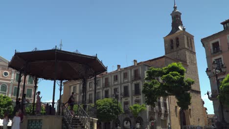 Pabellón-Con-Turistas-En-La-Plaza-Principal-De-Segovia-Con-Iglesia-En-Segundo-Plano.