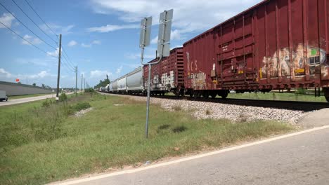 A-short-clip-of-a-fast-moving-train,-going-through-an-intersection,-in-the-middle-of-the-day