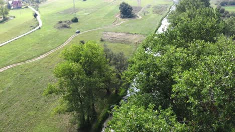 Luftaufnahme-über-Baumwipfeln,-Die-Den-Fluss-An-Einem-Sonnigen-Sommertag-In-Lika-Kroatien-Freigibt