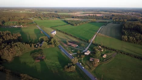 Verfolgen-Sie-Die-Aufnahme-Eines-Heißluftballons-über-Dem-Famland-Und-Den-Feldern-In-Valmiera,-Lettland