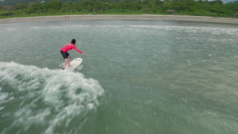 4K-Aerial-Drone-Following-Shot-of-Surfer-Taking-Lesson-in-Tambor,-Costa-Rica