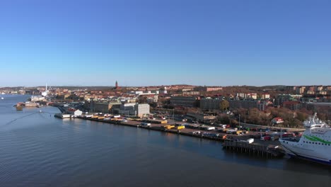 Aerial-drone-view-tracking-towards-berth-in-Gothenburg,-Sweden,-with-Stena-Line-Ferry-berthed-alongside,-on-a-clear-cloudless-day