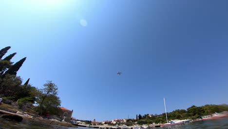 Airplane-flying-above-a-marina-and-near-by-beach-in-Cavtat