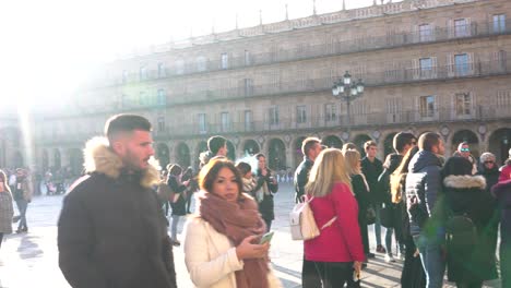 Salamanca,-Spain---December-7,-2019:-Tour-guide-surrounded-by-people-begins-the-visit-in-the-main-square-of-the-city-of-Salamanca