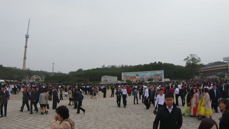 Walking-through-a-crowd-of-pedestrians-through-a-busy-square-in-Pyongyang,-North-Korea