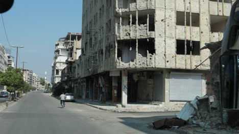 Vorderansicht-Des-Busses,-Mann-Auf-Einem-Fahrrad-Entlang-Der-Straße-In-Der-Stadt-Homs