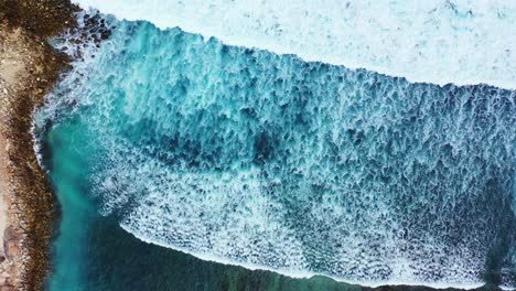 Große-Weiße-Wellen-Bedecken-Eine-Wunderschöne,-Ruhige-Lagune-Mit-Korallenriffen-Und-Kieselsteinen,-Die-An-Der-Felsigen-Küste-Der-Insel-In-Australien-Planschen