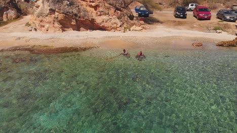 A-couple-enjoying-the-waves-crashing-at-the-beach-next-to-a-fortress-in-Curacao