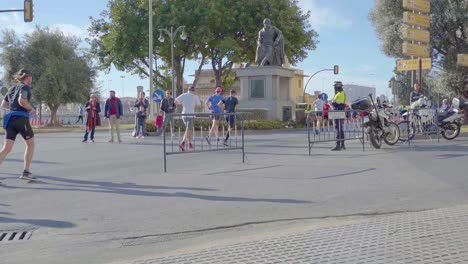 Gruppe-Von-Läufern,-Die-An-Einem-Polizisten-Vorbeilaufen,-Zürcher-Marathon-Málaga-2019