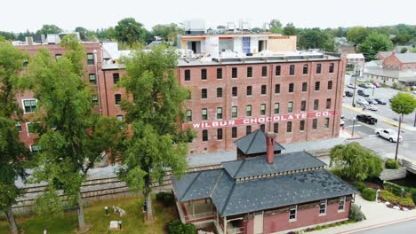 Antena-Desde-El-Parque-Lititz-Springs,-Histórica-Estación-De-Tren-Hasta-El-Edificio-Wilbur-Chocolate-Convertido-En-Condominios,-Construcción-En-Curso