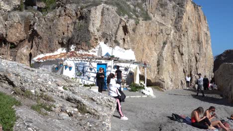 Tourists-Taking-Pictures-At-The-Beautiful-Beach-House-In-The-Rugged-Cliff-In-Playa-De-La-Calahonda,-Nerja,-Spain---wide-shot