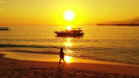Goldene-Meereslandschaft-Bei-Romantischem-Sonnenuntergang-Mit-Gelber-Sonne-Und-Himmel,-Die-Sich-Auf-Der-Leuchtenden-Meeresoberfläche-Spiegeln,-Silhouette-Von-Booten-Am-Ufer-Einer-Tropischen-Insel,-Indonesien