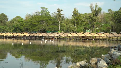 Hermoso-Lago-Huay-Tung-Tao-En-Chiang-Mai,-Fondo-De-Bosque-Exuberante,-Mostrando-Las-Cabañas-De-Paja-En-La-Orilla-Del-Lago