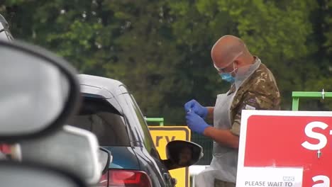 Army-nurse-wearing-face-mask-testing-public-at-corona-covid-virus-centre-shelter-hanheld-closeup