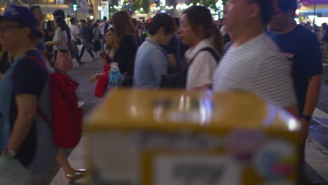 Menschen,-Die-Am-Shibuya-Kreuz-In-Tokio-Spazieren-Gehen,-Werden-Vom-Gelben-Kasten-In-Der-Mitte-Der-Straße-Aus-Gesehen
