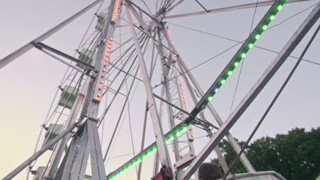 Angehaltenes-Riesenrad-An-Einem-Warmen-Sommerabend,-Weitwinkelaufnahme,-Nach-Oben-Geneigt,-Zeitlupe