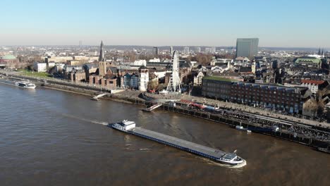 Drone-Footage-of-Duesseldorf-Altstadt-over-the-river-rhine,-city-center,-in-sunny-winter-weather,-cirular-motion-around-ship