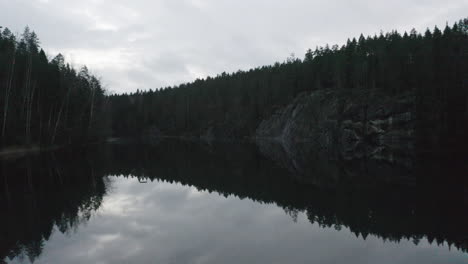 Calm-lake-with-mirror-water-surface-in-mysterious-forest