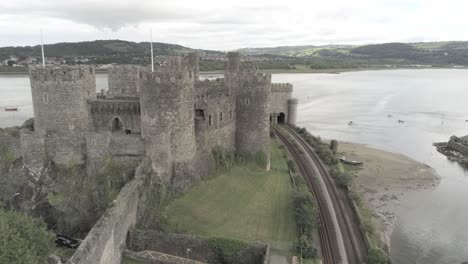 Aerial-view-above-Conwy-castle-Welsh-medieval-town-historic-landmark-descending-push-in