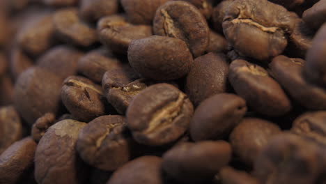 Up-close-macro-view-of-freshly-roasted,-brown-coffee-beans-to-be-used-for-hot,-black-coffee-rotating-left