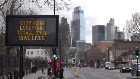 Vehicles-pass-a-road-sign-on-Whitechapel-Road-in-East-London-that-says-“Stay-home,-essential-travel-only,-save-lives”-during-the-Coronavirus-outbreak